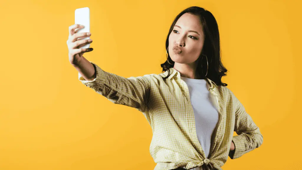 woman taking a selfie duck face yellow
