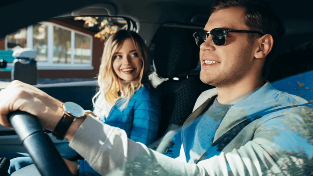 man and woman driving sunglasses watch smiling