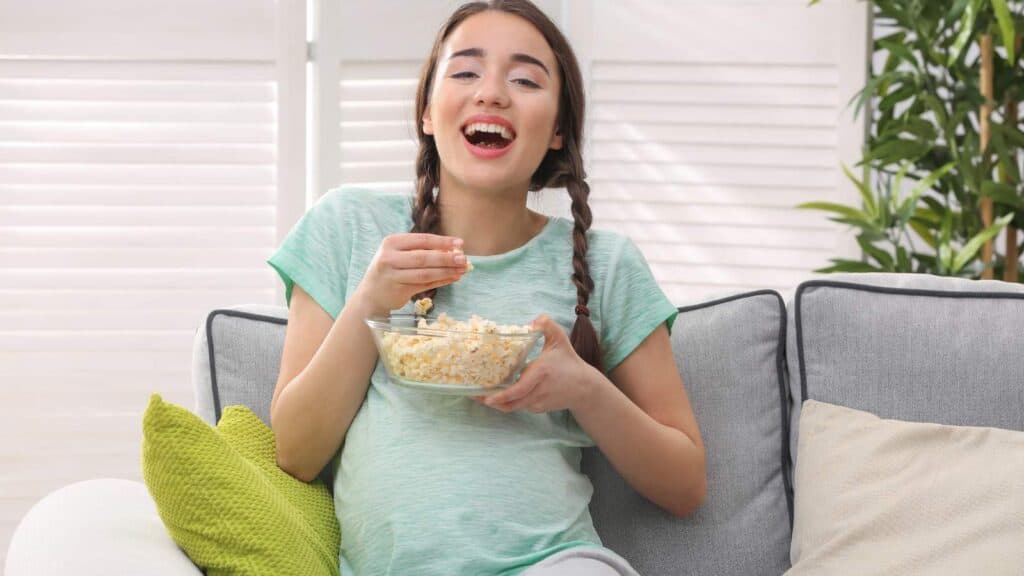pregnant woman eating popcorn