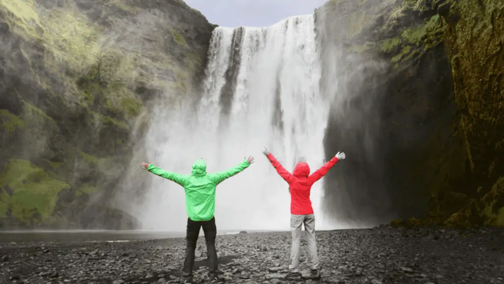 couple iceland waterfall rain jackets travel tourist