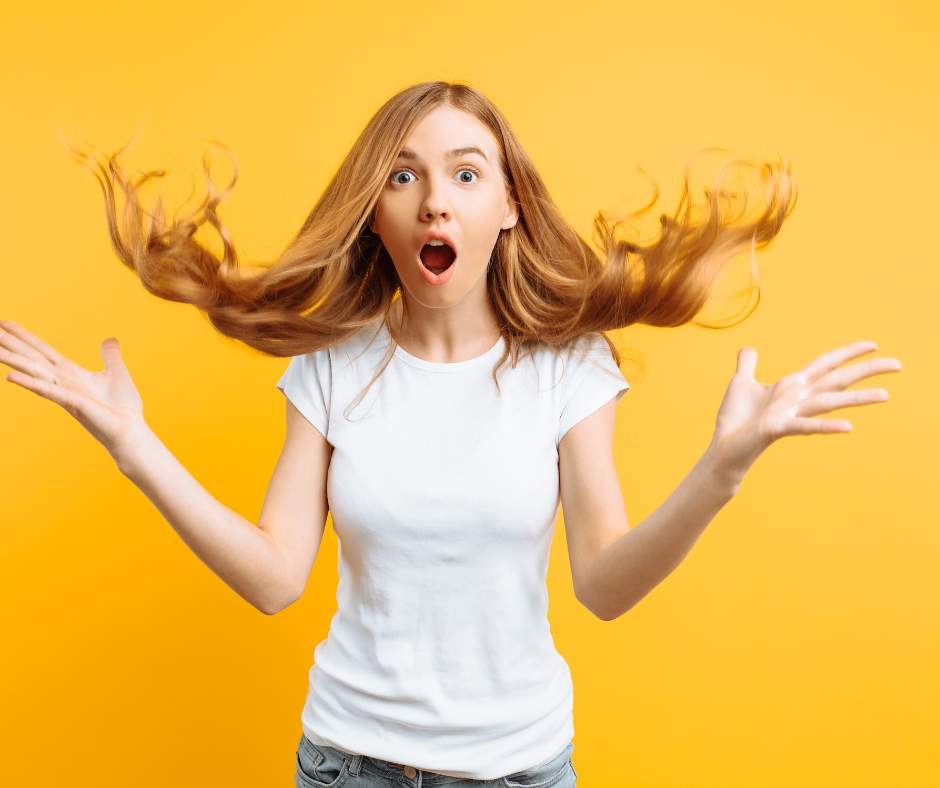 shocked woman with her hands and hair flying