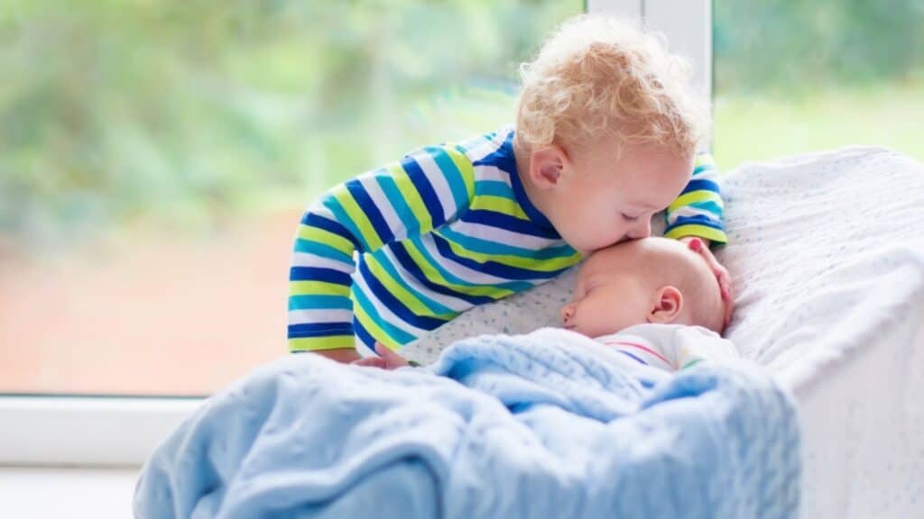 irish twins baby and toddler kissing baby