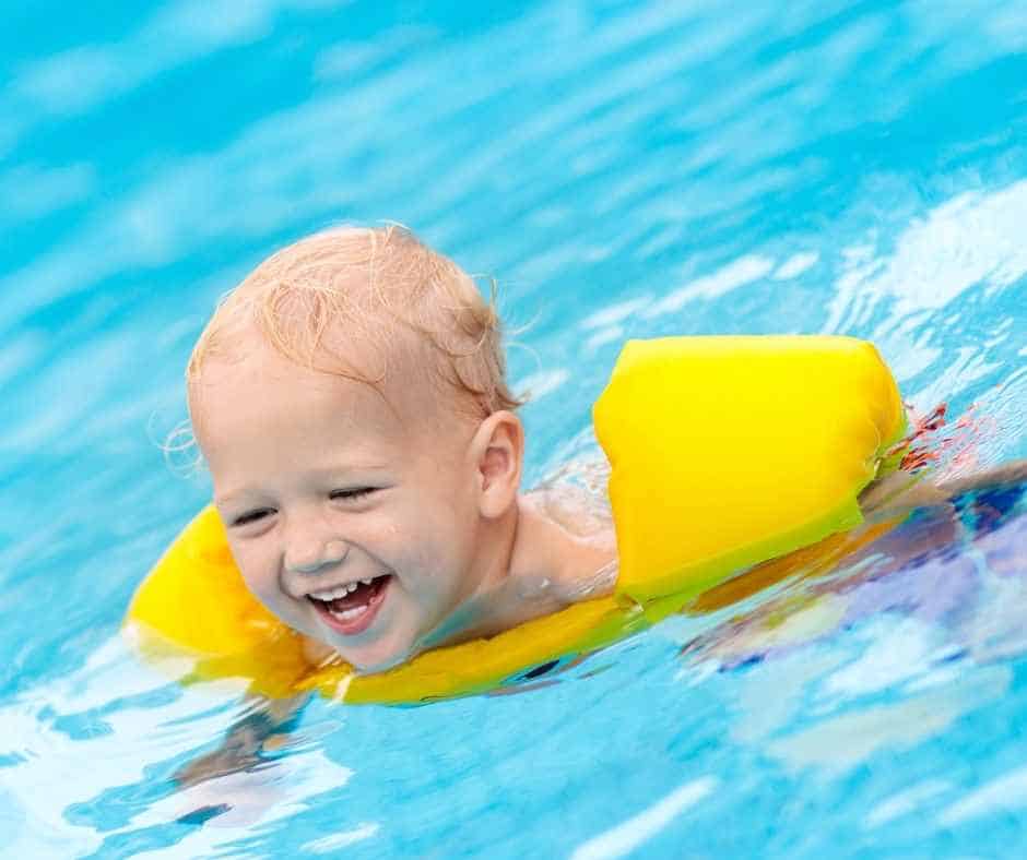cute toddler swimming in a life vest