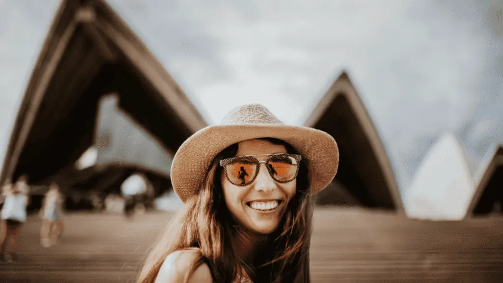 Woman tourist sunglasses hat smiling happy Sidney Australia opera house