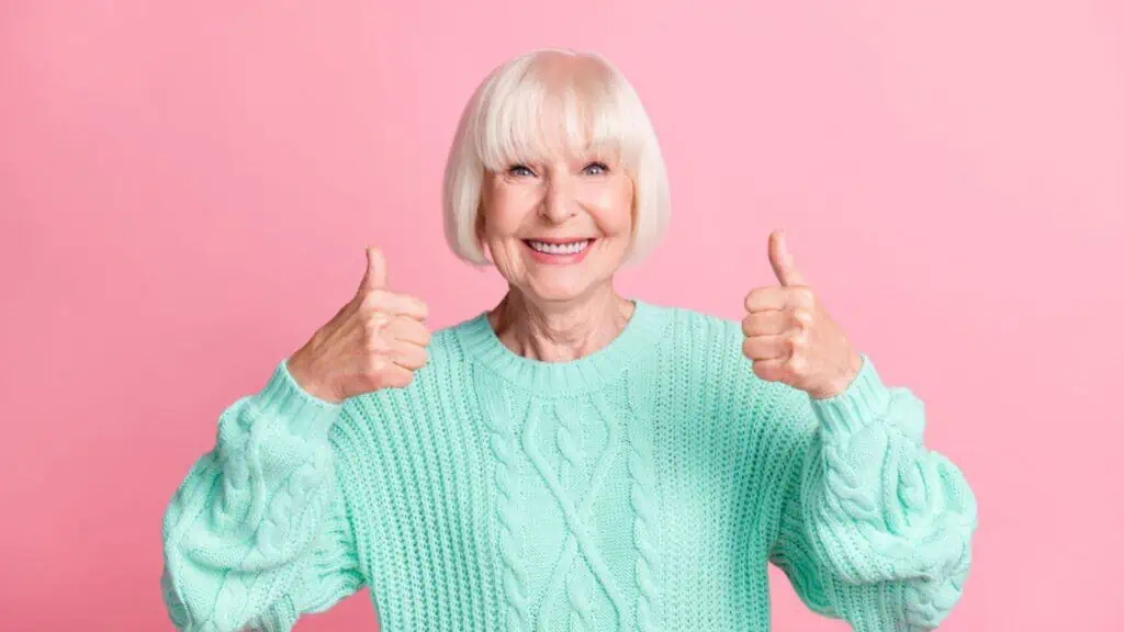 Adorable happy old woman showing thumbs up