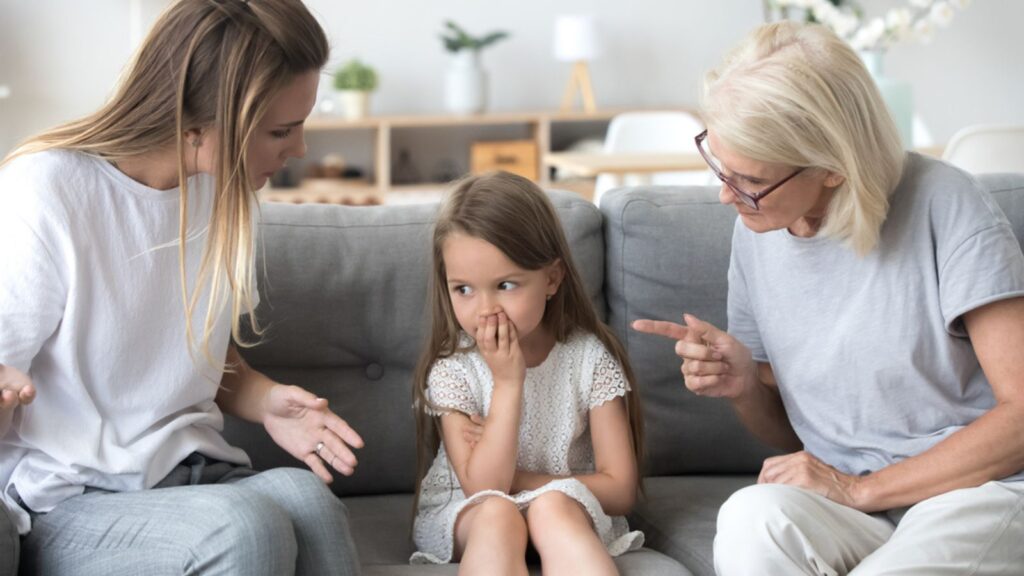 Angry mother and grandmother scolding little upset girl together