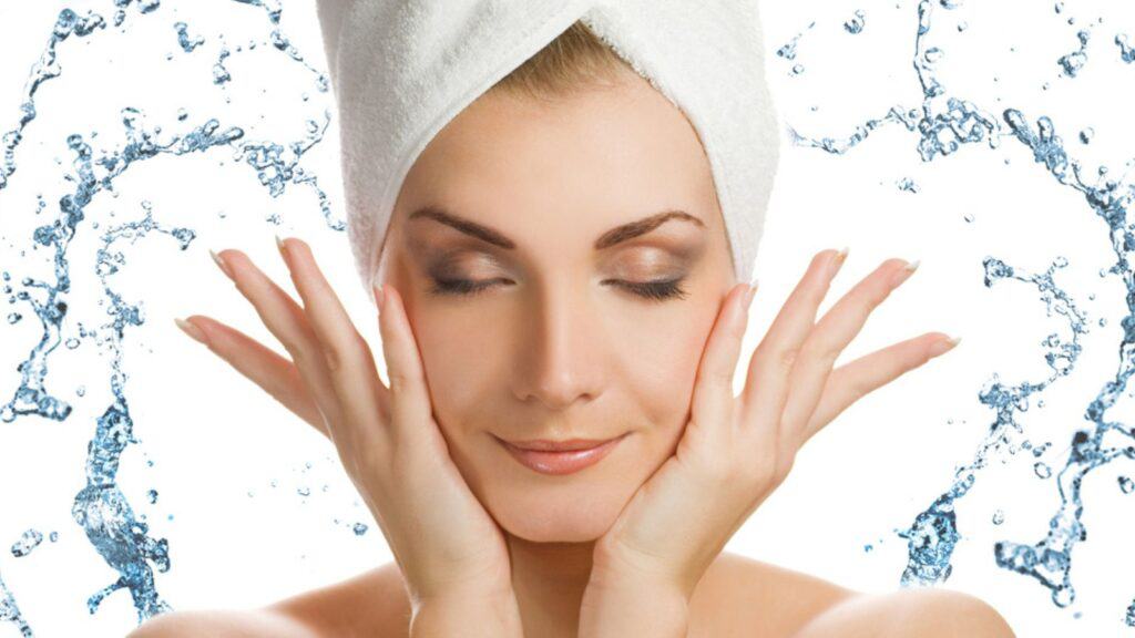 Beautiful young woman washing her face