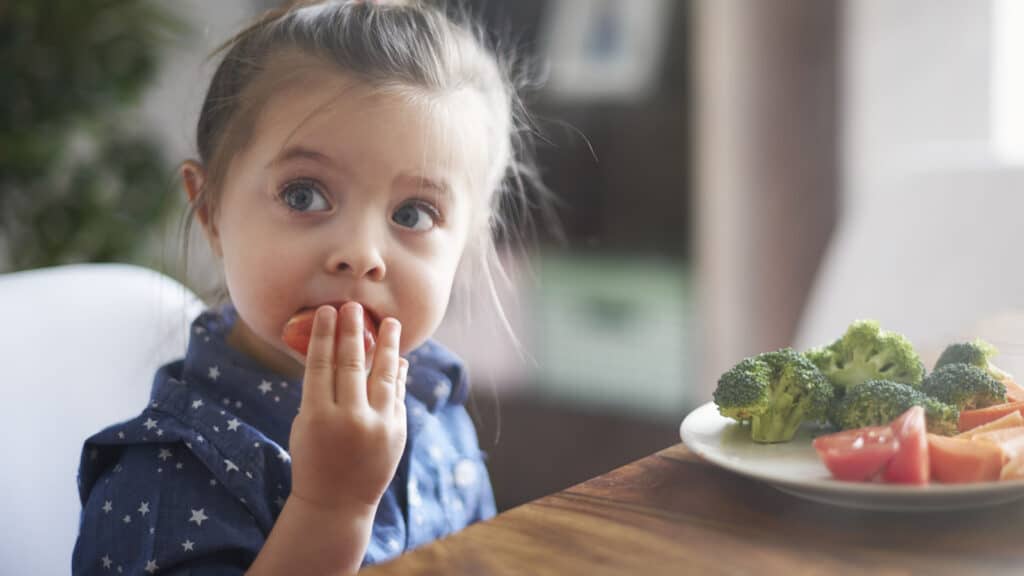 little girl eating fruit