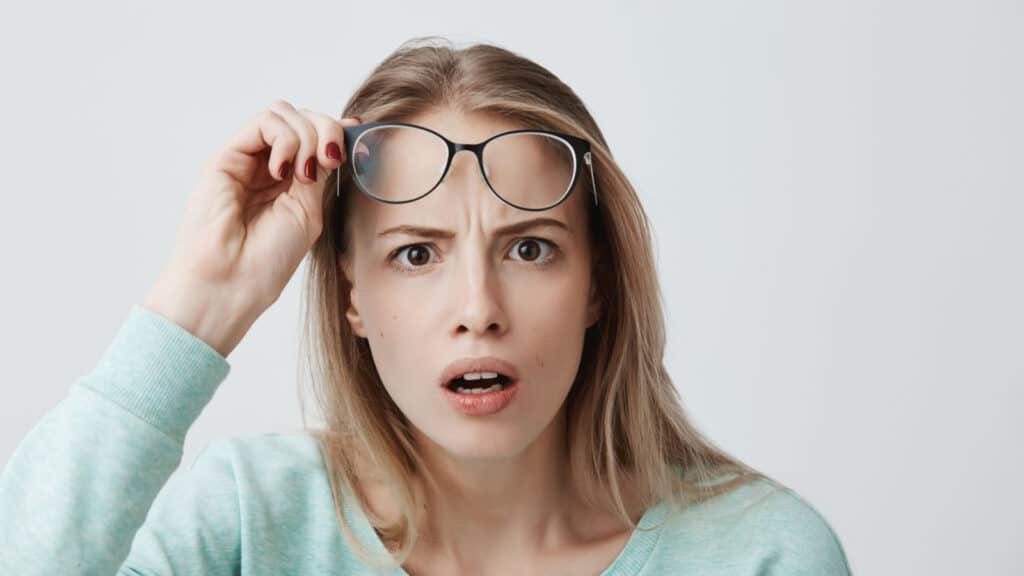 shocked woman lifting her glasses