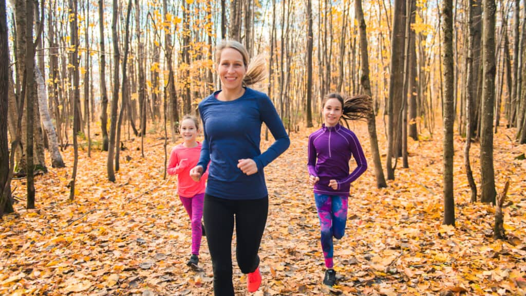 mom running with girls in woods