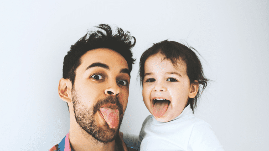 dad and baby sticking out their tongues