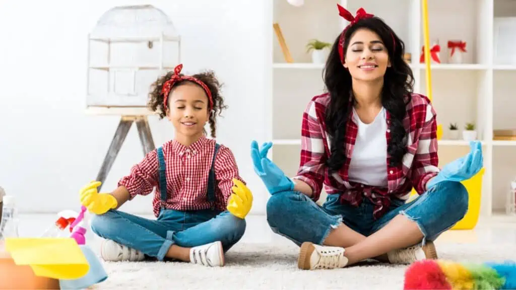 Calm mother with cute daughter sitting in lotus pose