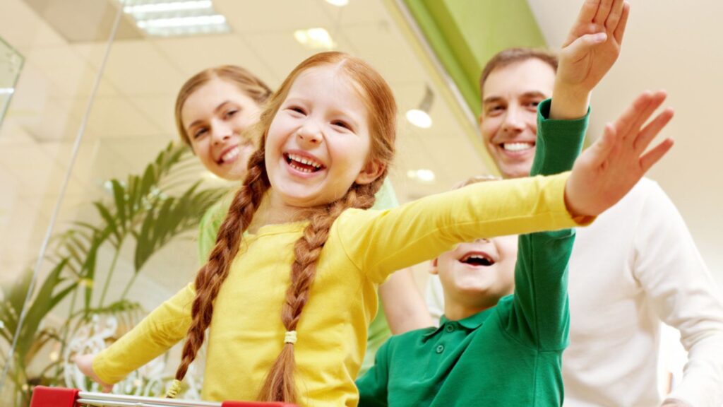 Children sitting in the cart pushed by parents