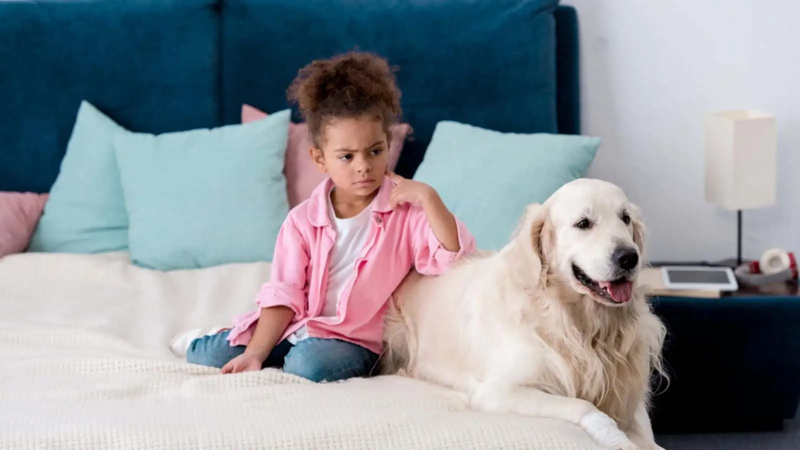 Confused african american kid leaned on her dog retriever