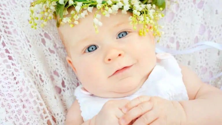 Cute baby and flower lily of the valley