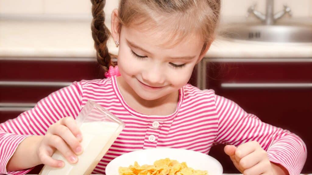Cute little girl having breakfast cereals