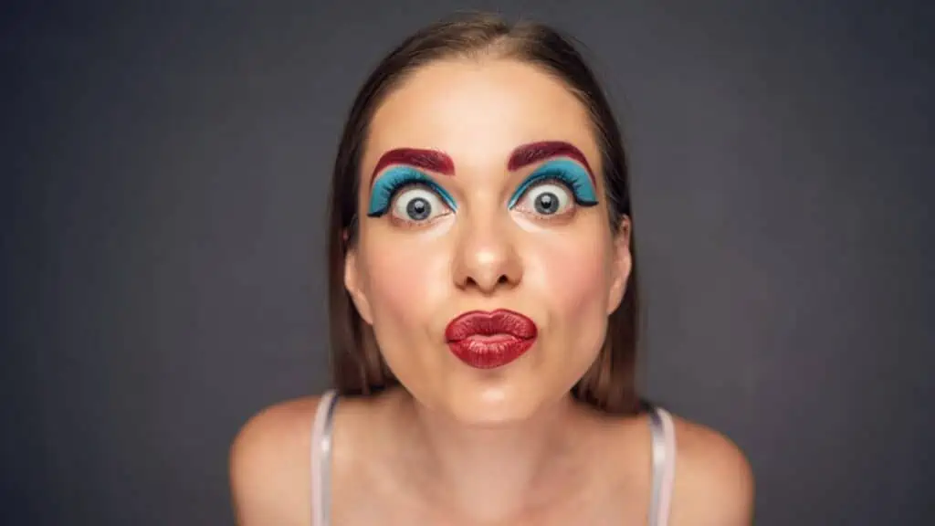 Face portrait of emotional crazy woman doing duck kiss lips