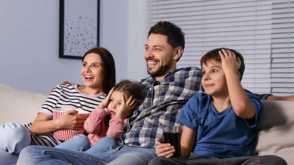 Family watching TV at home in evening
