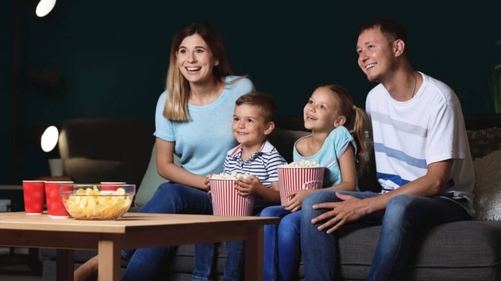 Family watching a movie with popcorn