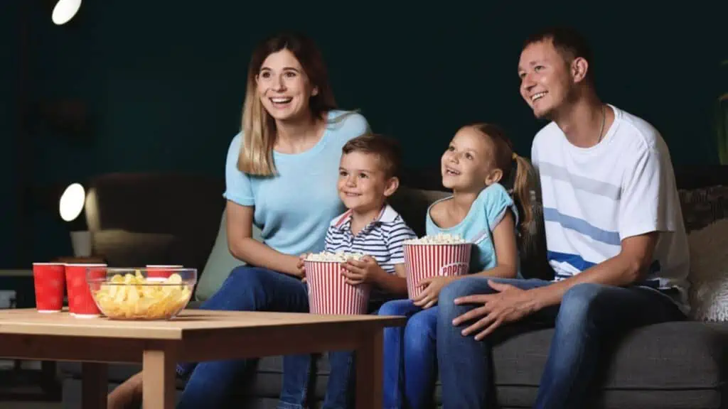 Family watching a movie with popcorn