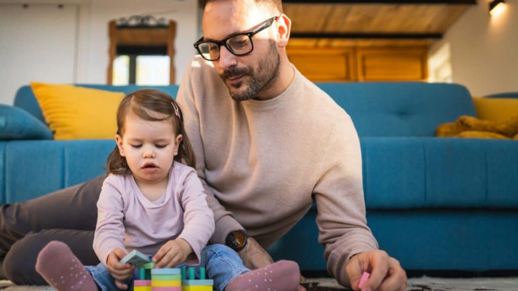 Father and daughter play on the floor at home