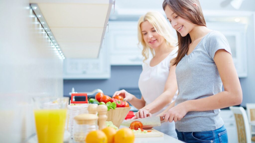 Girl and her mother cooking in kitchen