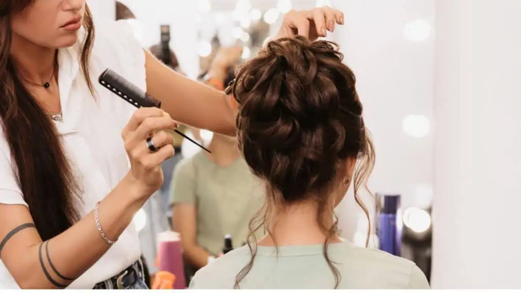 Hairstylist fixing woman's hair