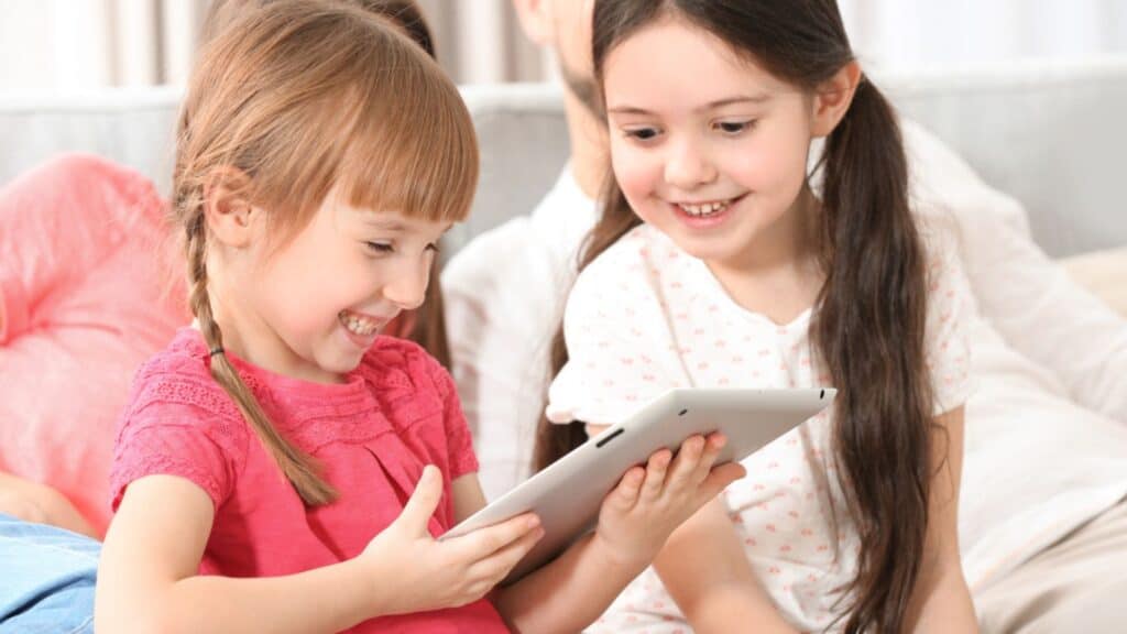 Happy Little girls with tablet at home