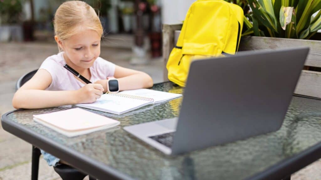 Happy caucasian kid has online lesson on laptop