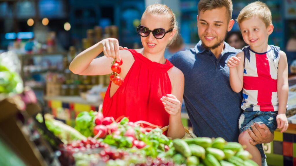 Happy family buys vegetables in the market