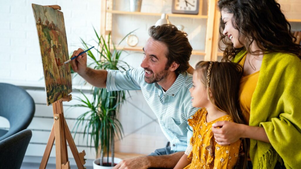 Happy family concept. Young smiling parents with children painting together
