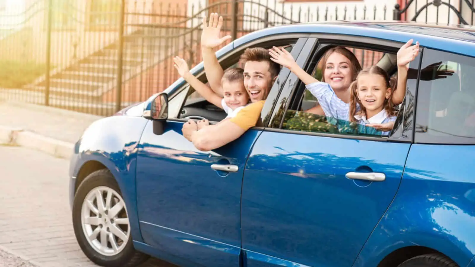 Happy family travelling by a blue car