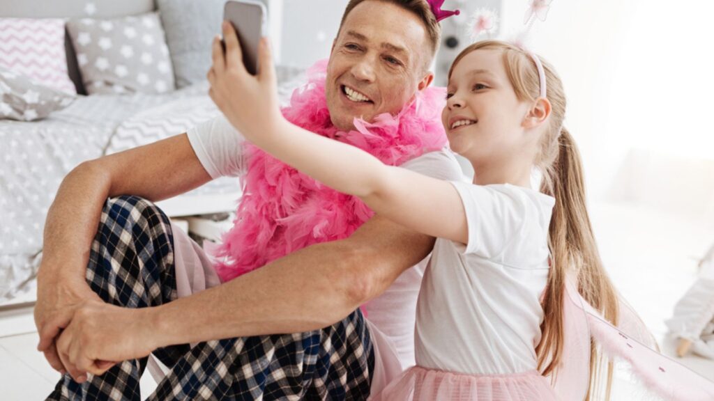 Happy father and daughter posing in the camera with their dress-up