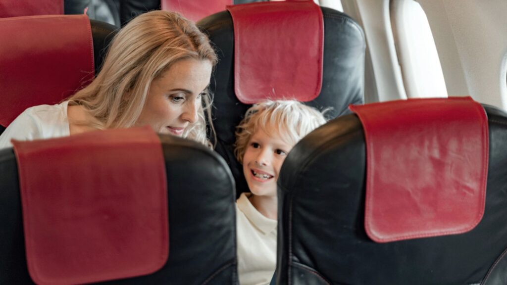 Happy mother with her son sitting in plane
