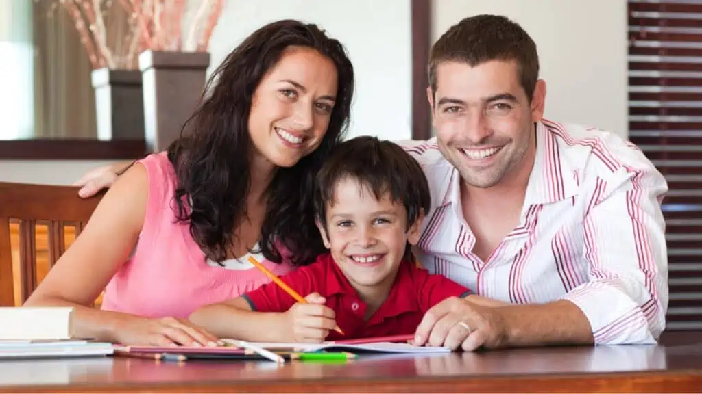 Happy parent helping their son for homework