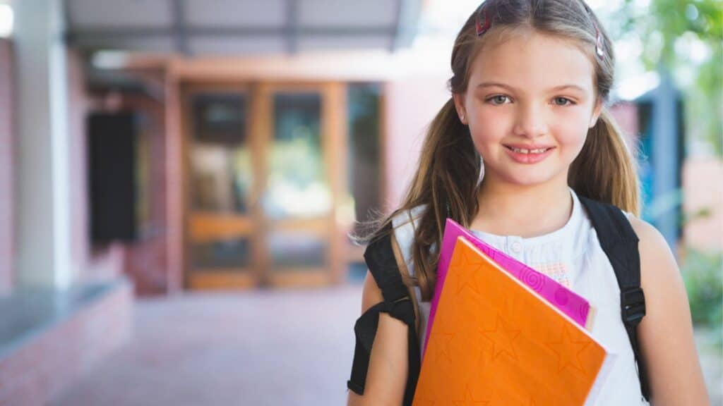 Happy school kid standing in corridor