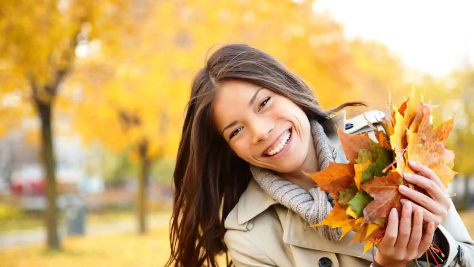 Happy woman playing with leaves