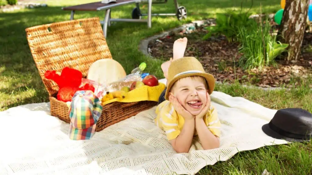 Laughing boy resting next to the wicker basket