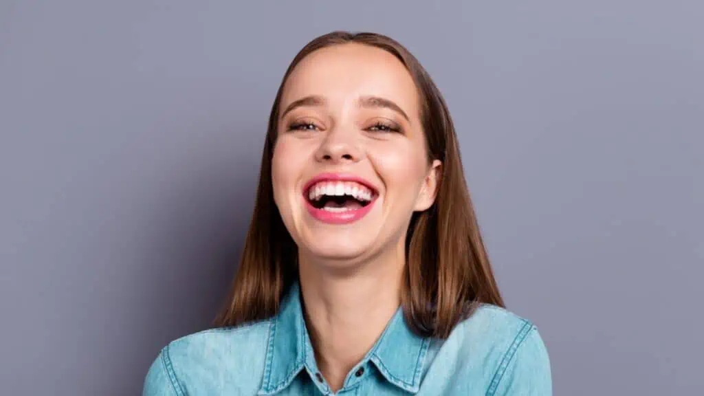 Laughing woman in grey background