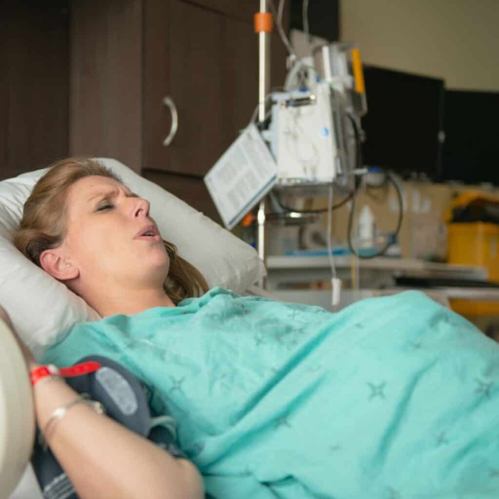 woman in labor lying on her bed