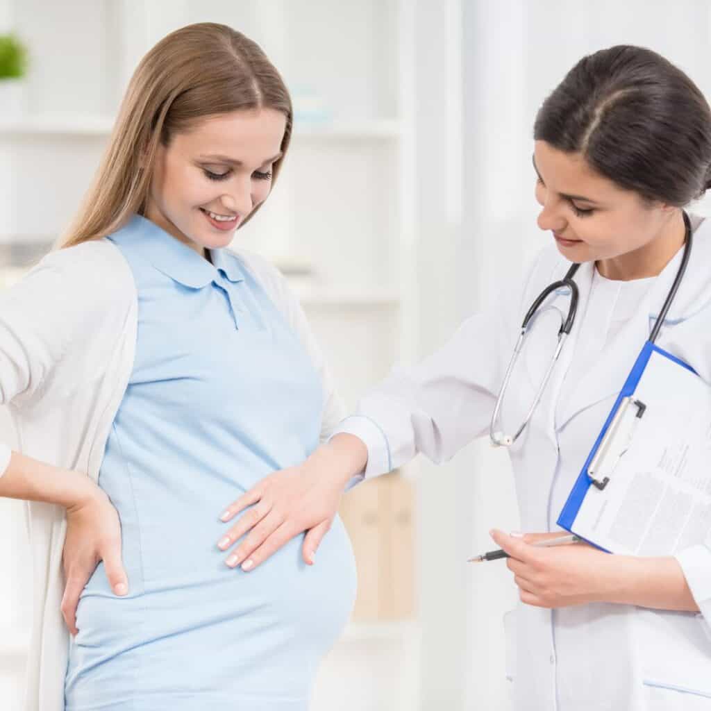 Doctor touching a pregnant woman's belly