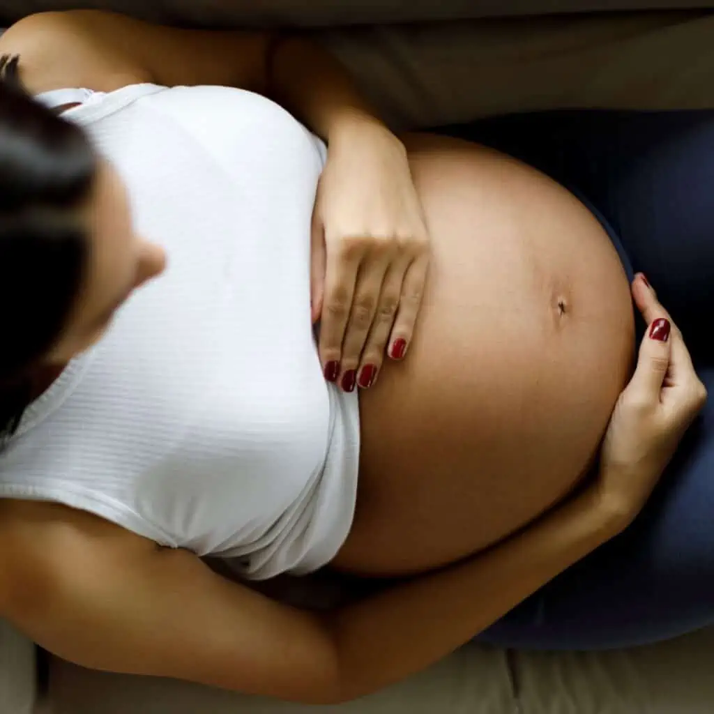 a pregnant woman touching her own belly