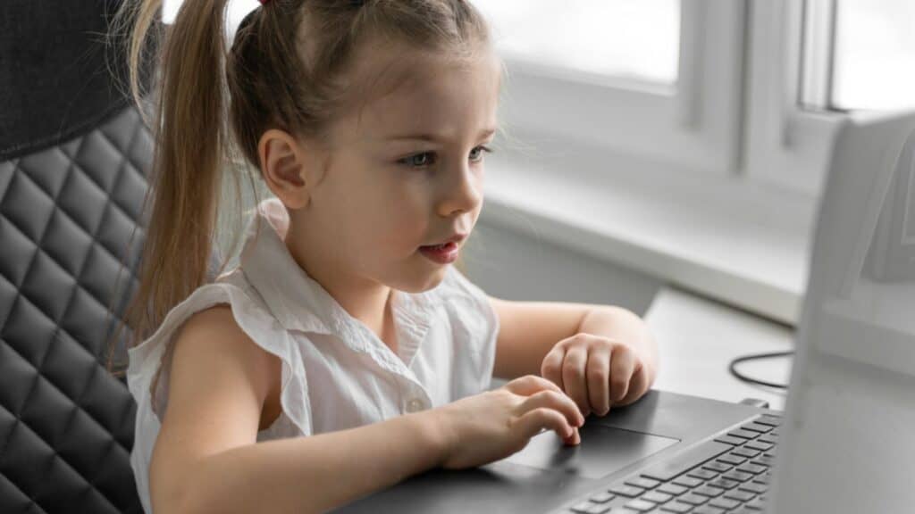 Little Caucasian girl studying online at home