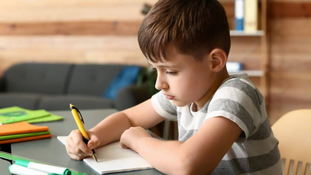 Little boy doing homework in room
