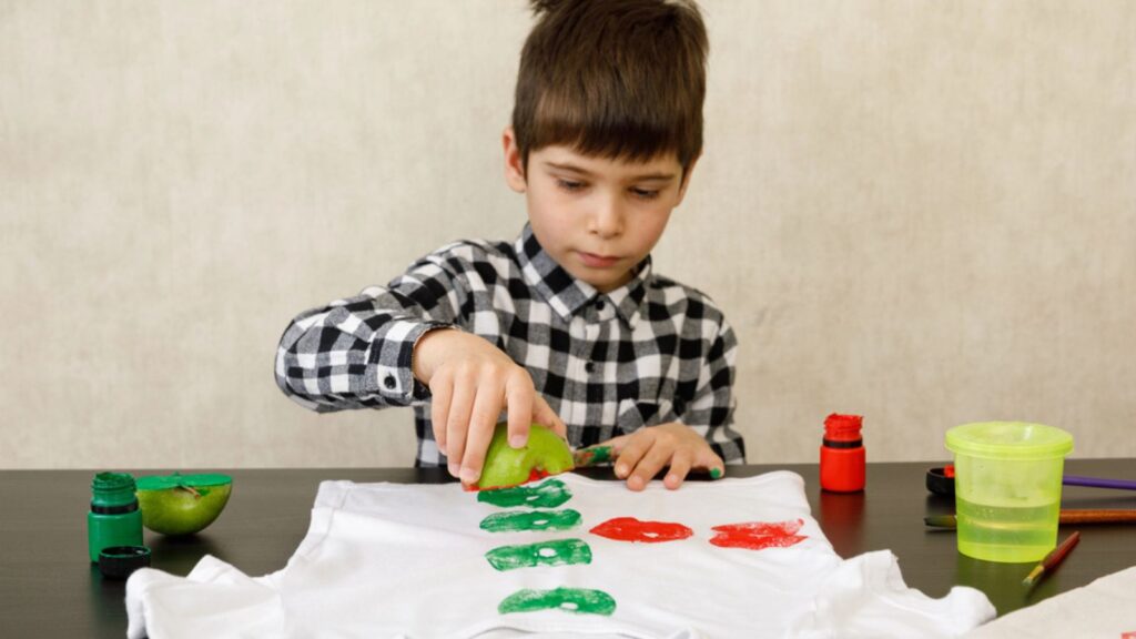 Little boy painting the tshirt clothes to be printed