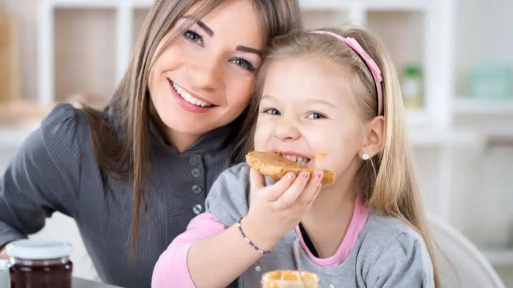 Little girl eating peanut butter sandwich