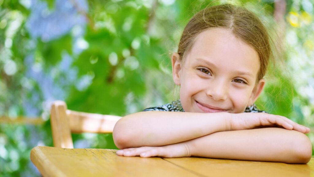 Little girl sitting at table