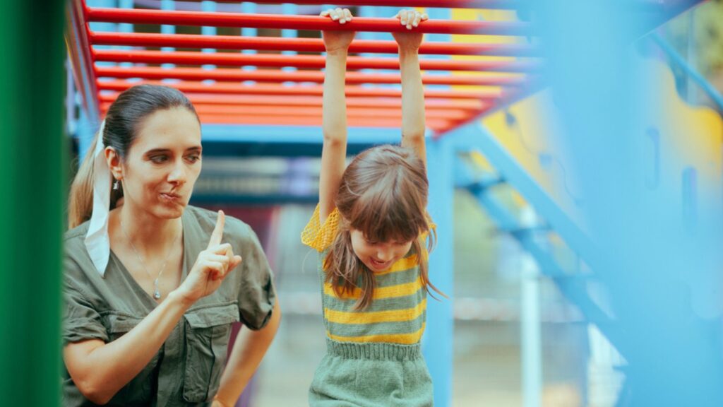Mom Forbidding her little girl to Climb on a Dangerous Playground Equipment