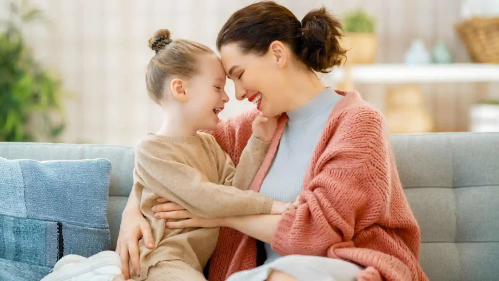 Mom and her daughter child girl are playing, smiling and hugging at home