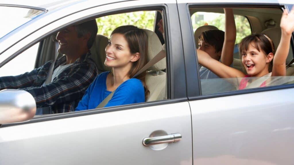 Mom driving a car with her family